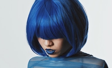 a woman with blue hair is posing for a picture