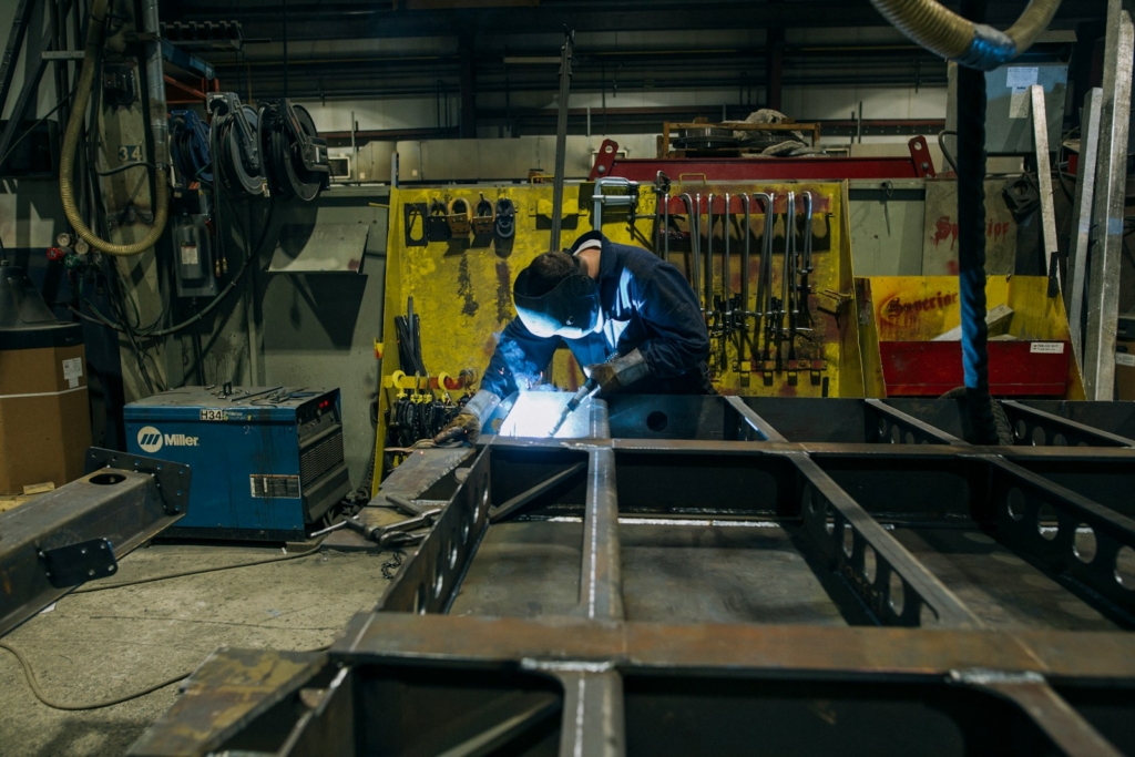 a man in a factory working on a piece of metal